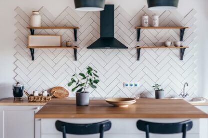 Inteligentne gniazdko w minimalistycznej kuchni pozwala na kontrolowanie zużycia energii przez sprzęty kuchenne. Płytki na ścianie.