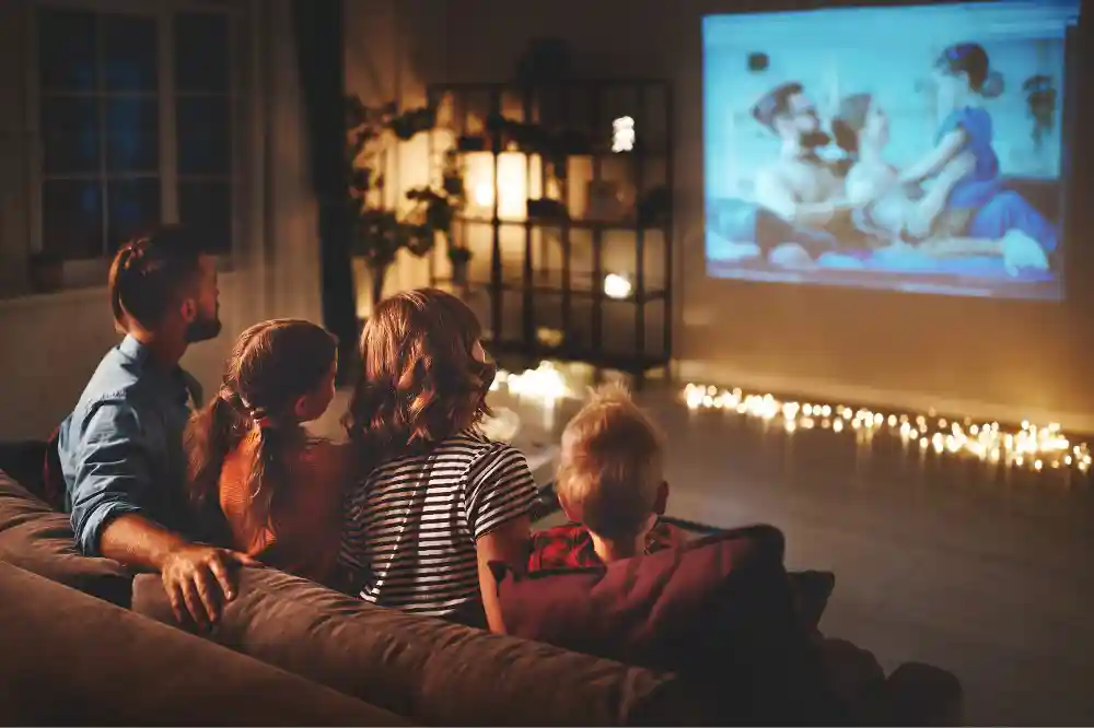 The family watches a movie enjoying the evening at home, they spend time together with the light dimmed thanks to the intelligent dimmer, they can enjoy the right atmosphere.