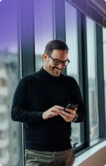 Mężczyzna trzyma smartfon. Zdalnie steruje inteligentnym domem Smart Home Keemple.